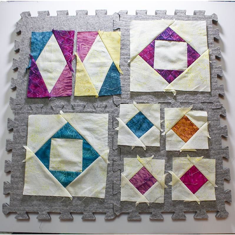Colorful quilt blocks on Wool Press n Lock Tiles wool pressing mats for your design wall