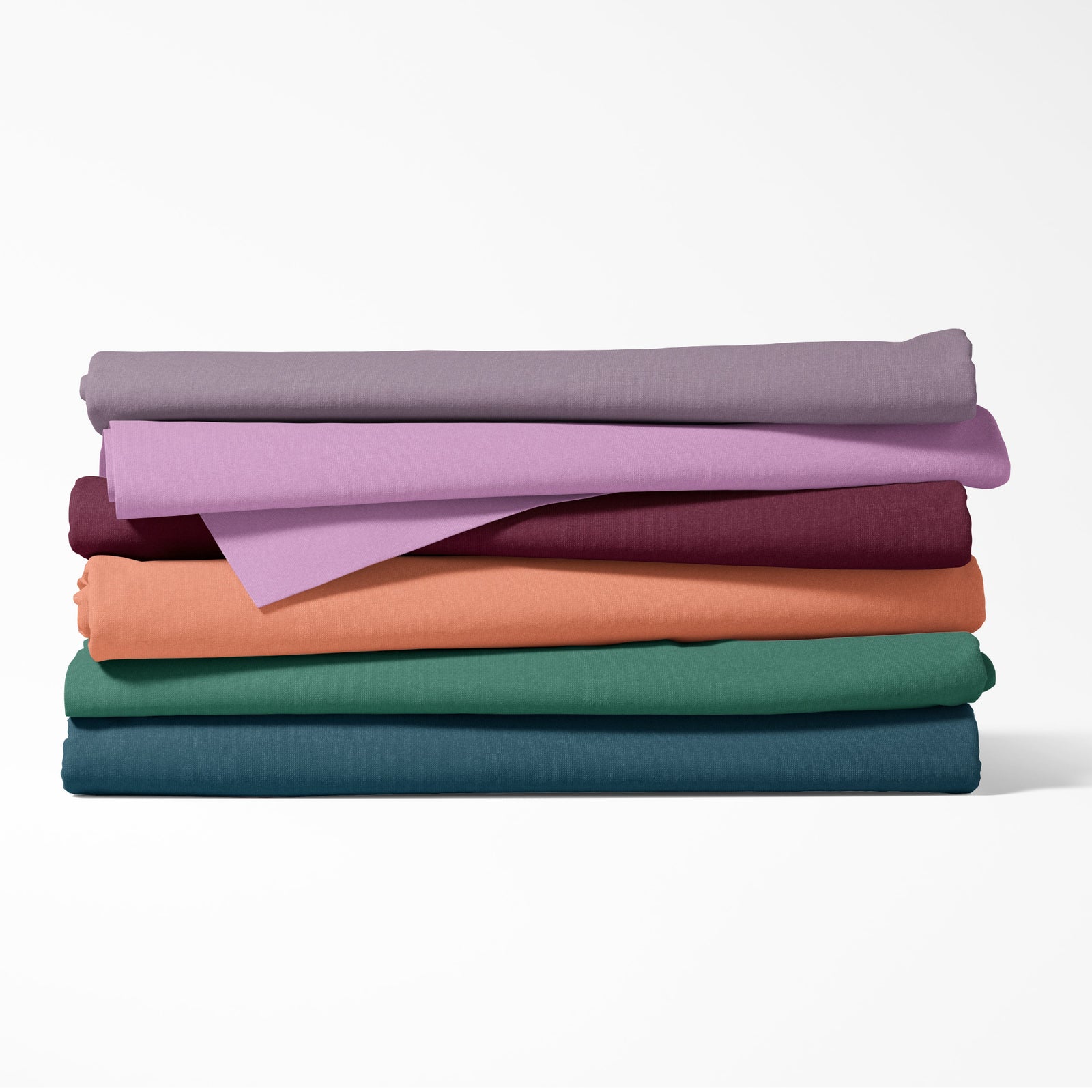Stack of folded fabric sheets in various colors on a white background