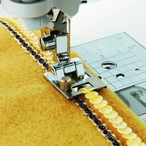 Sewing machine with low shank snap-on adapter attaching sequined trim to yellow fabric