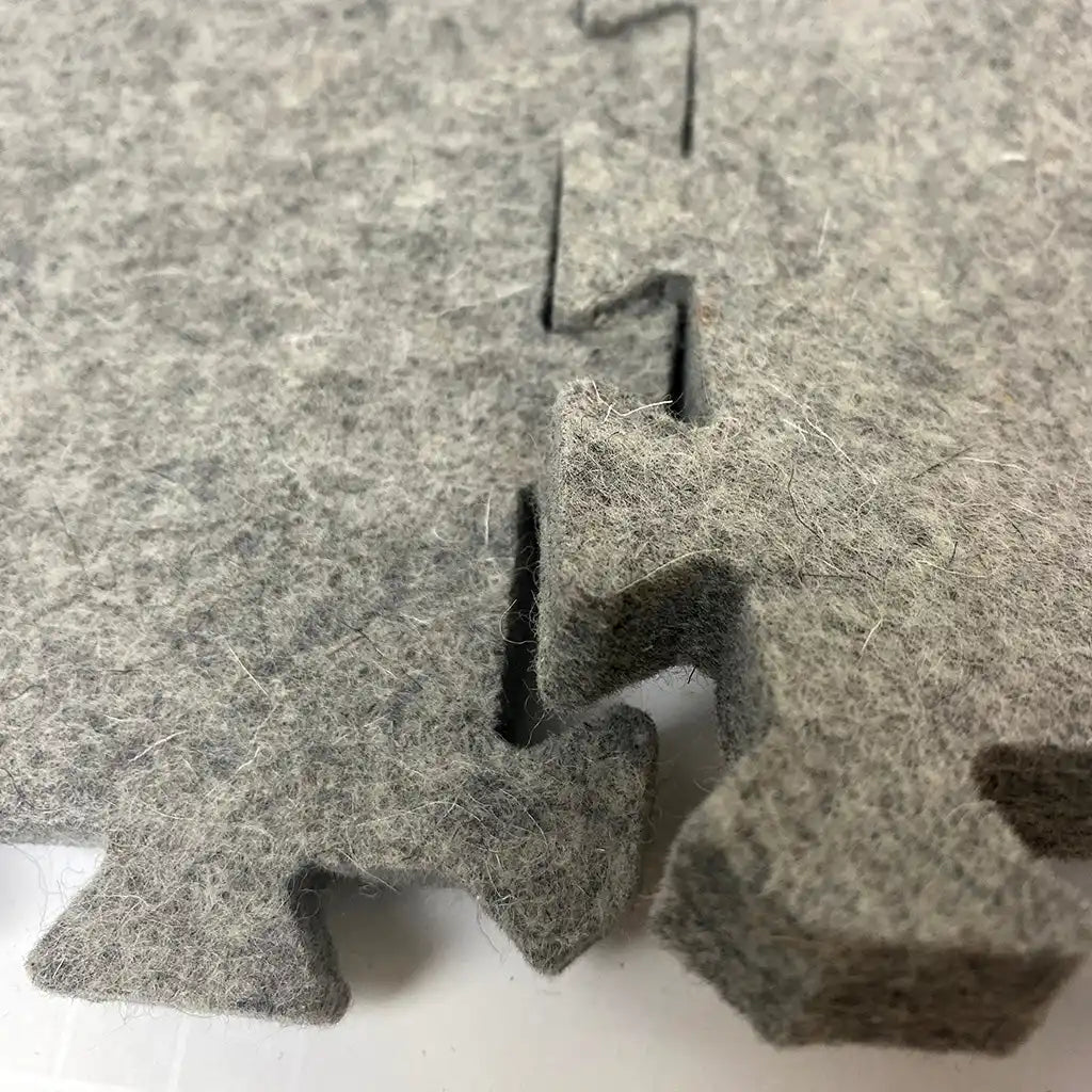 Interlocking gray felt puzzle mat.
