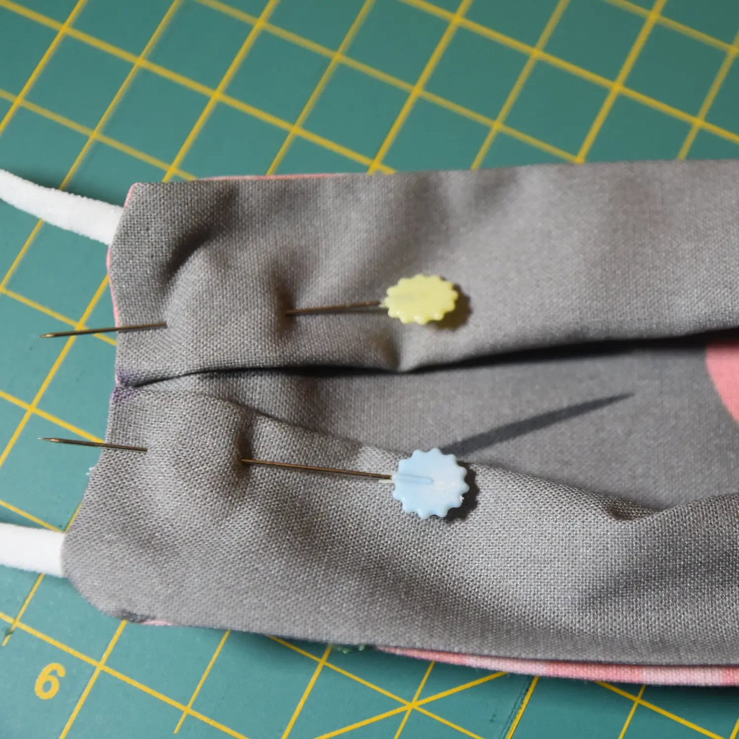 Pin pleats on sides of mask