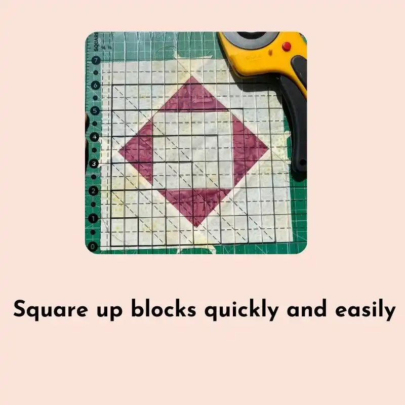 A quilter’s rotary cutter and square-up ruler used on a fabric block.