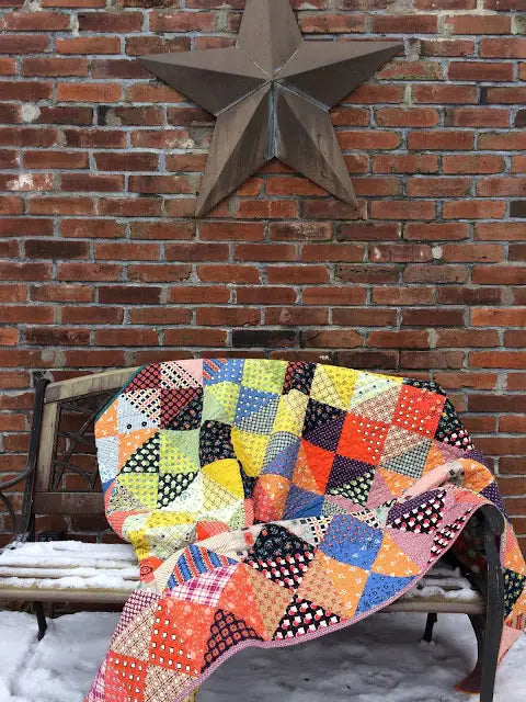 scrap quilt drapped on bench.jpeg