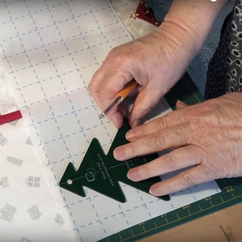 Dark green plastic Christmas tree quilting template for free motion quilting with Steam-A-Seam 2 fusible web
