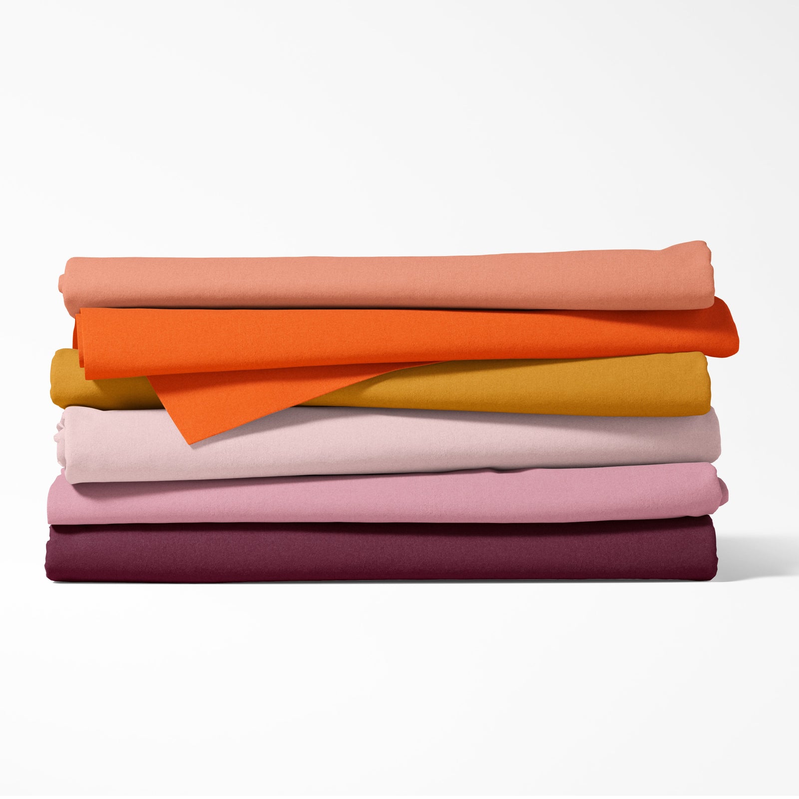 Stack of folded fabric sheets in various colors on a white background