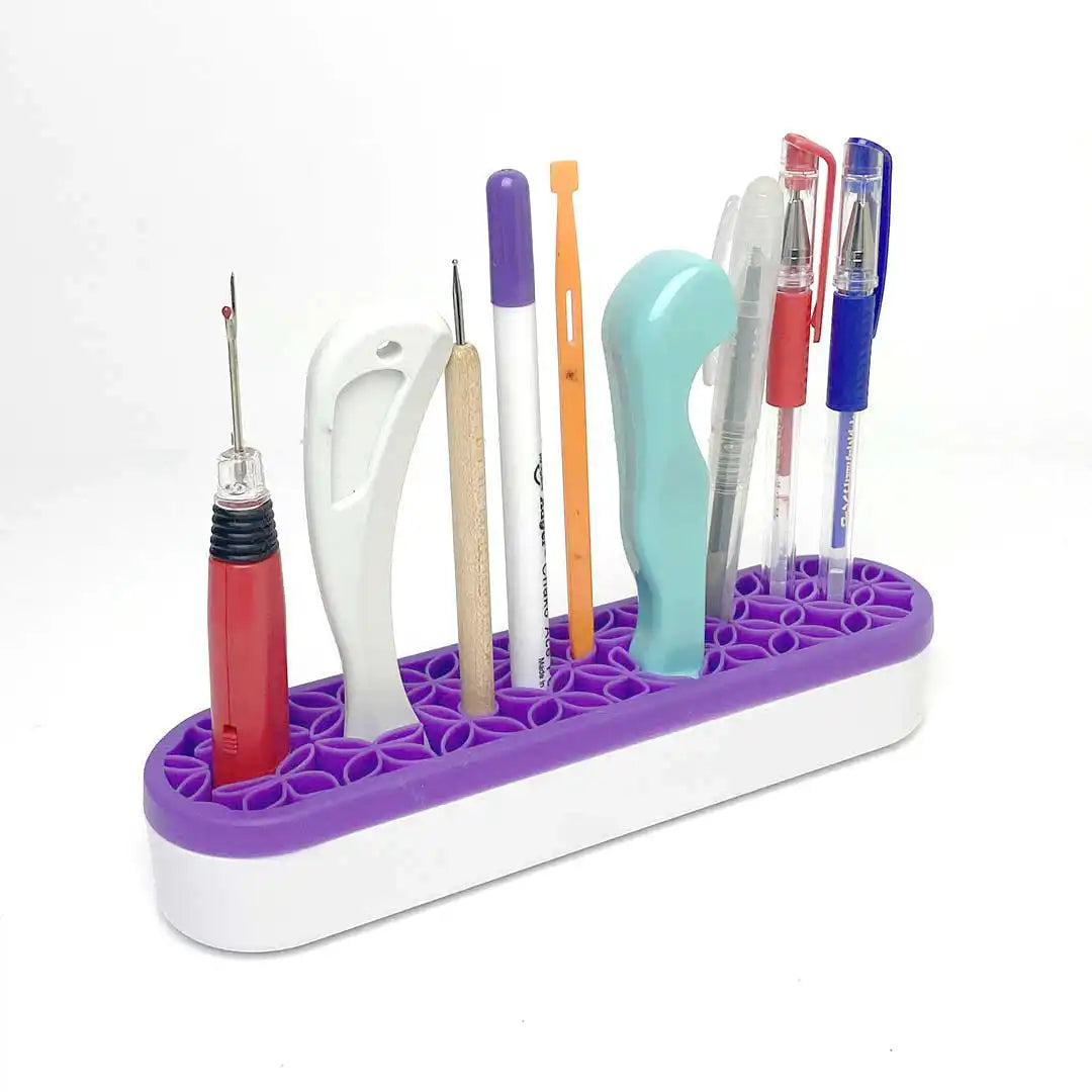 A white and purple oblong desk organizer filled with various crafting tools and pens.